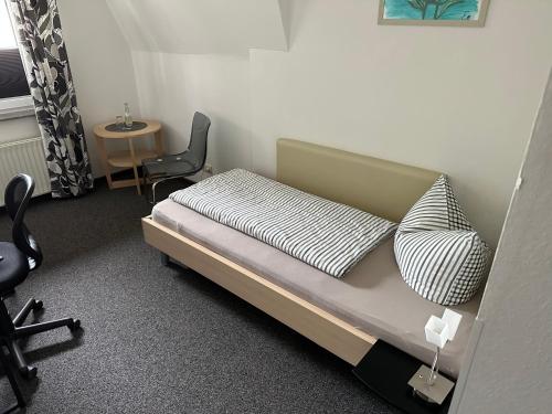 um quarto com uma cama, uma cadeira e uma mesa em Gasthaus Unikat em Unterlüß
