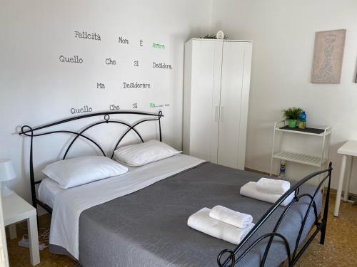 1 dormitorio con 1 cama con 2 toallas en Night & Day, en Pisa