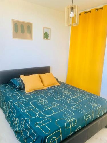 - une chambre dotée d'un lit avec une couverture bleue et jaune dans l'établissement Le COSY T3 climatisé des Calanques de Morgiou, à Marseille