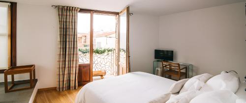 a bedroom with a bed and a sliding glass door at Hotel Rural Quercus Tierra in Garganta de los Montes