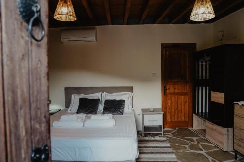 a bedroom with a white bed with two pillows at The Stonehouse Suites in Limassol