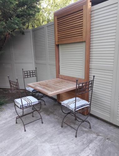 una mesa de picnic y dos sillas junto a una valla en chambre privée chez l'habitant, en Carpentras
