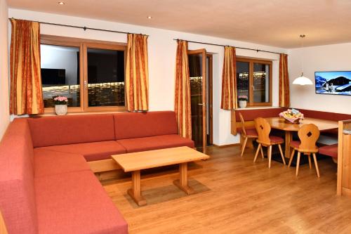 a living room with a couch and a table at Appartements neben der Gondelbahn - Haus Nord in Brixen im Thale