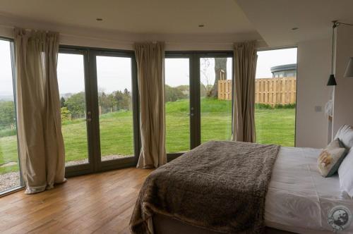 um quarto com janelas grandes e uma cama grande em Lethnot Broch em Forfar