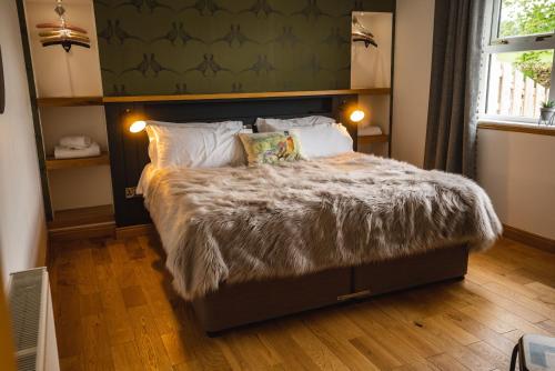 um quarto com uma cama grande e um edredão peludo em No 2 Balbinny em Forfar