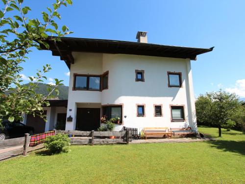ein großes weißes Haus mit einem Rasenhof in der Unterkunft Charming Apartment in Kirchdorf in Tirol near City Centre in Kirchdorf in Tirol