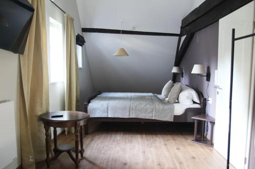 1 dormitorio con cama, mesa y TV en Friends&Family Veldenz M, en Veldenz