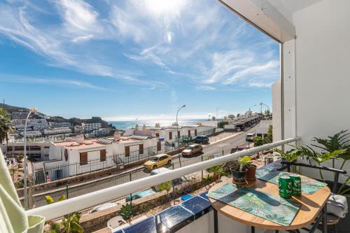 Un balcón con una mesa y vista a una ciudad. en Puerto Rico Corner, en Puerto Rico de Gran Canaria