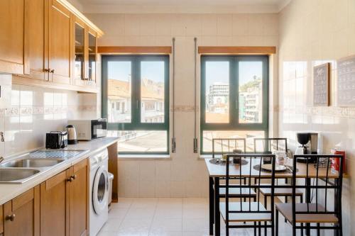 a kitchen with a sink and a table with chairs at Miguel Torga Gold III in Coimbra