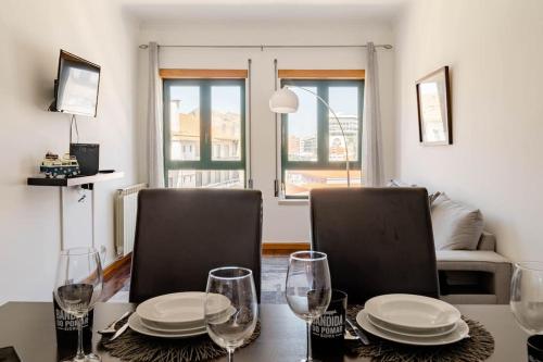 a dining room table with two chairs and plates and glasses at Miguel Torga Gold III in Coimbra