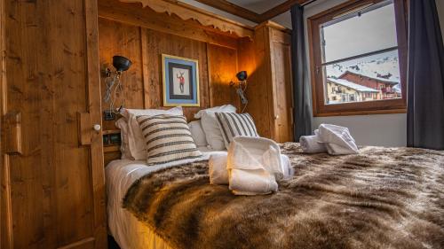 a bedroom with a large bed with a window at Arc 1950 Appartement skis aux pieds in Arc 1950