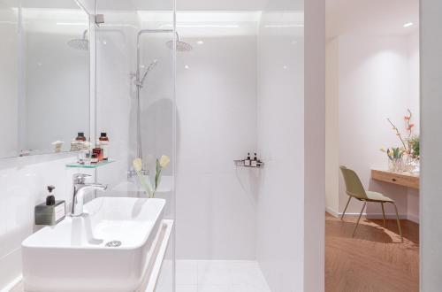 a white bathroom with a sink and a shower at M Village Điện Biên Phủ Q3 in Ho Chi Minh City