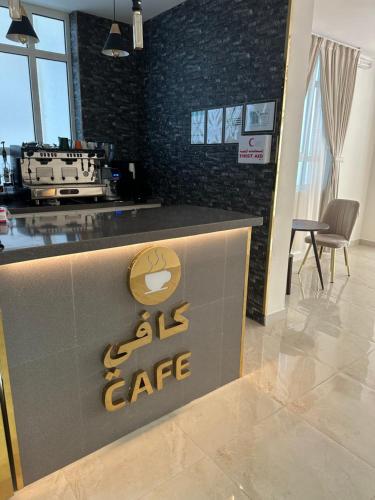 a cafe with a sign on a counter in a room at الاتحاد الذهبية للشقق المخدومة 3 in Al Hofuf