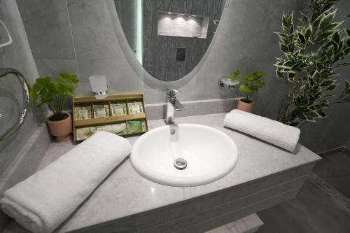 bagno con lavandino bianco e specchio di منتجع اجمكان Ajmkan Resort a Al Khobar
