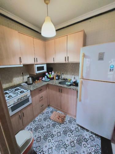 eine Küche mit einem weißen Kühlschrank und einem Herd in der Unterkunft شقة مفروشة مطلة ع مسبح in Bursa