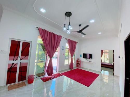 ein Wohnzimmer mit roten Vorhängen und einem roten Teppich in der Unterkunft HELLOKITTY HOUSE - Unit 1 in Kuala Terengganu
