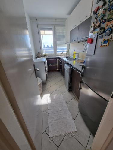 a kitchen with a refrigerator and a tile floor at Ušće apartman in Novi Beograd