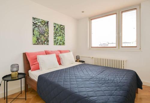 una camera da letto con un letto con una coperta blu e due finestre di Old town 2BR with best view a Bratislava