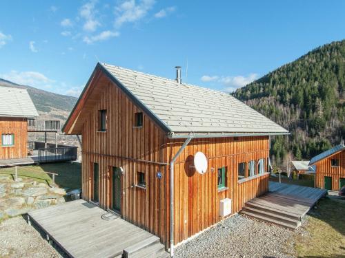 Cosy Chalet in Stadl an der Mur with Valley Views في Stadl an der Mur: كابينة خشبية كبيرة مع شرفة خشبية