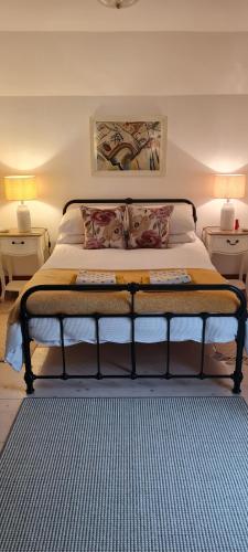 a bed in a bedroom with two night stands and two lamps at Delightful Devon Cottage in East Budleigh