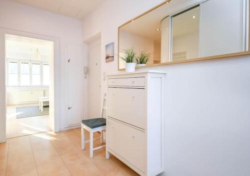 a white kitchen with a sink and a mirror at Cozy 2BR in heart of old town in Bratislava