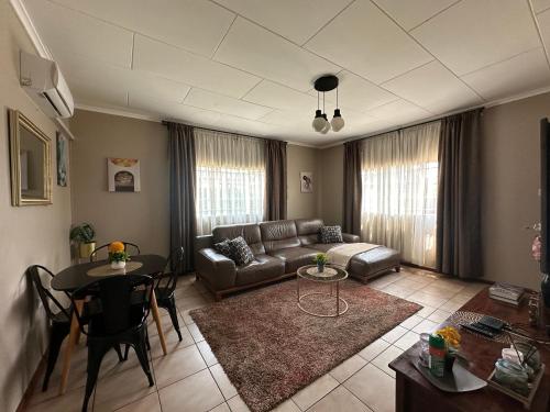 - un salon avec un canapé et une table dans l'établissement Serene 3 bedroom house in Olympia, Lusaka, à Lusaka
