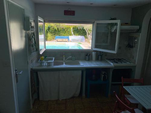 Il comprend une cuisine avec un évier et offre une vue sur une terrasse. dans l'établissement Maisonette proche VÉLODROME, à Marseille