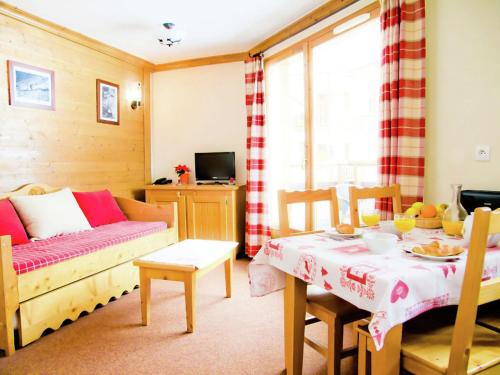 ein Wohnzimmer mit einem Tisch und einem Sofa in der Unterkunft Rustic apartment on the slopes in cozy Val Cenis in Lanslebourg-Mont-Cenis
