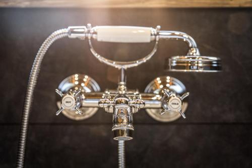 eine Dusche mit Duschkopf und Duschkopf in der Unterkunft Alte Schule auf der Alm in Teuchl