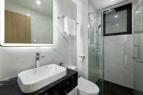 a bathroom with a sink and a glass shower at Ami House 1 in Hanoi