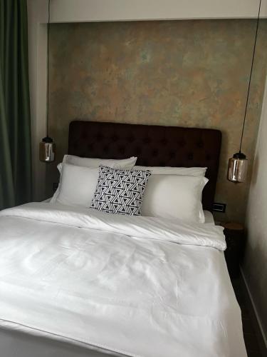 a bed with white sheets and pillows on it at Vlasinsko jezero VILA BEST in Surdulica