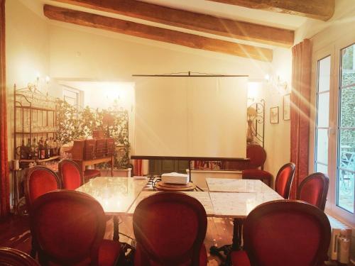 une salle de conférence avec une table, des chaises et un écran dans l'établissement Hôtel Restaurant U Castellu Vizzavona, à Vizzavona