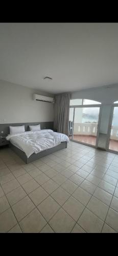 a bedroom with a bed and a tiled floor at شاطئ البحر Durrah Al Arus in Durat Alarous