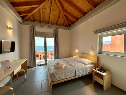 una camera con letto e vista sull'oceano di Pasithea Suites a Monemvasía