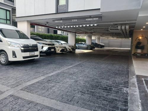 a parking lot with cars parked in front of a building at Wellness Stay & Hotel Sukhumvit 107 in Bangna