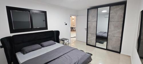 um quarto com uma cama e um espelho grande em כוכב הצפון em Quriate-Chemoná
