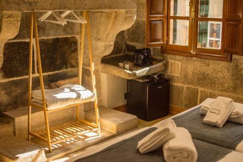 a bedroom with two beds and a stone wall at hostal Nomade Santiago in Santiago de Compostela