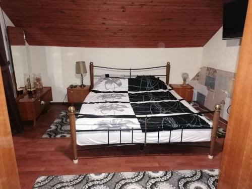 sypialnia z łóżkiem z czarno-białą kołdrą w obiekcie Kuća za odmor Dunavski raj w mieście Batina