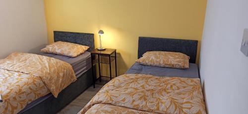une chambre avec deux lits et une table avec une lampe dans l'établissement Broxtowe house -3 bed House parking Nottingham, à Nottingham