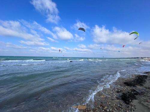 a group of people flying kites over the ocean at Trullo Alessandro e Villa Raffaela in San Vito dei Normanni
