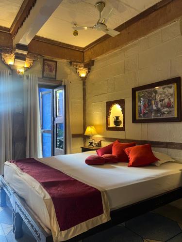 a bedroom with a large bed with red pillows at Raj Mandir Boutique Home Stay in Jodhpur