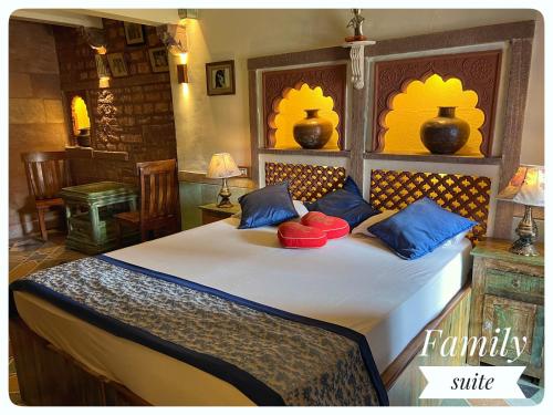 a bedroom with a large bed with blue and red pillows at Raj Mandir Boutique Home Stay in Jodhpur