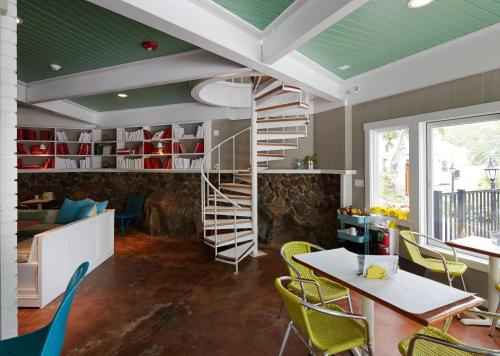 a spiral staircase in a room with a table and chairs at The Lodge on the Cove in Kennebunkport