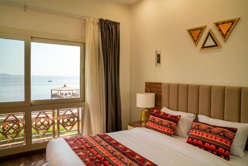 a bedroom with a bed and a view of the ocean at Azal Lagoons Resort Abu Simbel in Abu Simbel