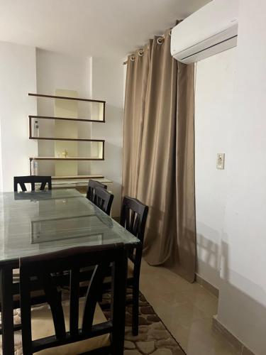 ein Esszimmer mit einem Tisch, Stühlen und einem Vorhang in der Unterkunft Vellar in Madinaty