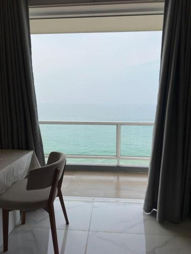 a bedroom with a chair and a large window at PL BEACH FRONT APARTMENT in Bopitiya