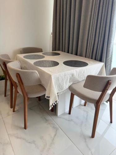 a table and chairs with a white table and a table and chairs at PL BEACH FRONT APARTMENT in Bopitiya