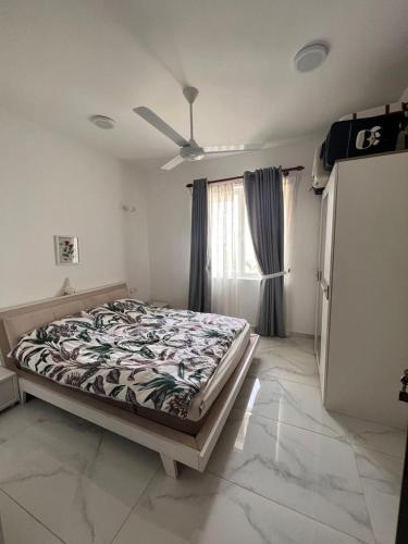 a bedroom with a bed in a room with a window at PL BEACH FRONT APARTMENT in Bopitiya