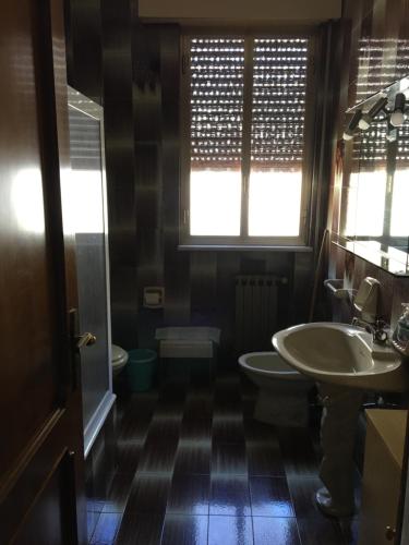 bagno con 2 lavandini, servizi igienici e finestra di Affittacamere al piano terra a Scicli