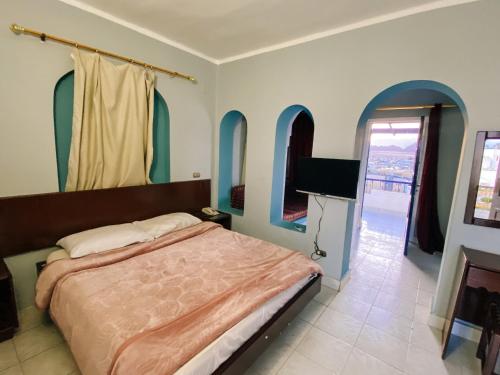 um quarto com uma cama e uma televisão de ecrã plano em Halomy Sharm Resort em Sharm el Sheikh